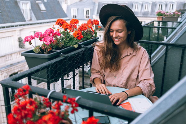 woman-digital-nomad-balcony-laptop-work__opdb-op61dd70a34d9981-72620389